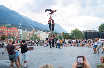 The Funky Monkeys Akrobatik-Show mit beeindruckender Performance am vertikalen Mast (Chinese Pole) vor Gebirgskulisse.