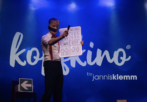Mentalmagier Jannis Klemm fasziniert das Publikum bei einer interaktiven Bühnenshow auf einem Firmenevent.