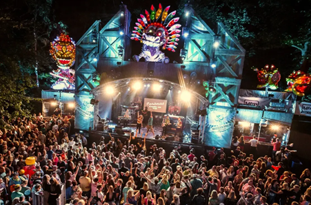 Die Musiker der Showband The Coronas performen live auf der Bühne, während im Hintergrund eine große Leinwand die aktuellen Songwünsche des Publikums anzeigt.